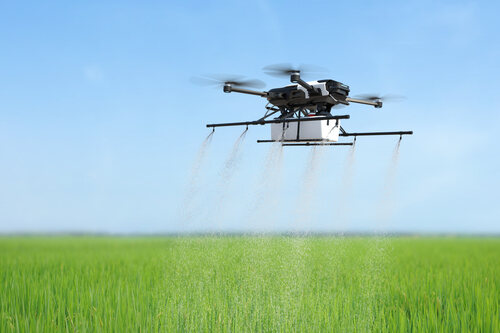 a drone spraying fertilizer on a farm